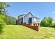 Exterior shot of the side of a two-story home with blue vinyl siding and a brick foundation at 4874 Thom Rd, Mebane, NC 27302