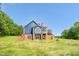 Exterior shot of the rear of a two-story home with a blue exterior and brick foundation at 4874 Thom Rd, Mebane, NC 27302