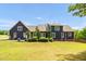 Back exterior of home showing blue siding, large windows, and attached garage at 4874 Thom Rd, Mebane, NC 27302