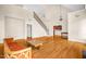 Open living room with hardwood floors, tall ceilings, and iron stair railing at 4874 Thom Rd, Mebane, NC 27302