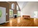 Sunlit living room with vaulted ceilings, fireplace, hardwood floors, and large windows at 4874 Thom Rd, Mebane, NC 27302