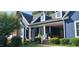 Inviting covered porch with rocking chairs and well-maintained landscaping at 4874 Thom Rd, Mebane, NC 27302