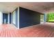Spacious covered back porch featuring stained wood flooring and ample room for seating at 4874 Thom Rd, Mebane, NC 27302
