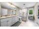 Bathroom with dual vanity sinks, a walk-in shower with glass doors, and updated fixtures at 5020 Mimosa Dr, Durham, NC 27713