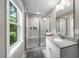 Bathroom featuring tiled shower with glass door, granite countertop and window at 5020 Mimosa Dr, Durham, NC 27713