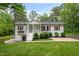 Charming brick home featuring a welcoming front porch, lush lawn, and beautifully landscaped shrubbery at 5020 Mimosa Dr, Durham, NC 27713