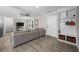 Living room with a gray couch, ceiling fan, and a TV, leading to an entryway and kitchen at 5020 Mimosa Dr, Durham, NC 27713