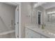 This bright bathroom has a large vanity mirror, tiled floors, and a commode behind a privacy door at 511 Hamilton Cottage Way, Raleigh, NC 27605
