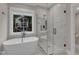 This bright bathroom has a glass shower, soaking tub, and large window with views of the home's exterior at 511 Hamilton Cottage Way, Raleigh, NC 27605