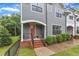 Townhouse entrance with a gray exterior, brick steps, and a cozy porch at 511 Hamilton Cottage Way, Raleigh, NC 27605