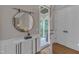 Stylish foyer with a round mirror, marble-topped console table, and hardwood floors at 511 Hamilton Cottage Way, Raleigh, NC 27605