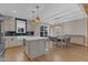 Modern kitchen featuring gray cabinets, an island, and a dining area with hardwood floors at 511 Hamilton Cottage Way, Raleigh, NC 27605