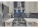 Close-up of a modern kitchen with stainless steel appliances and stylish backsplash at 511 Hamilton Cottage Way, Raleigh, NC 27605