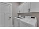 Well-lit laundry room with white cabinets and modern appliances at 511 Hamilton Cottage Way, Raleigh, NC 27605