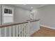 Upstairs landing featuring hardwood floors, window, and white wood staircase at 511 Hamilton Cottage Way, Raleigh, NC 27605