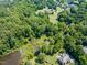 Aerial view of the property with lush greenery, a large pond, and scattered homes in a rural landscape at 5308 Stableview Ct, Holly Springs, NC 27540