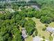 Aerial view of wooded acreage, houses and a pond within a picturesque community at 5308 Stableview Ct, Holly Springs, NC 27540