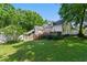 Expansive backyard with mature trees showcasing the home's deck and patio, perfect for outdoor living at 5308 Stableview Ct, Holly Springs, NC 27540