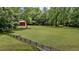 Backyard featuring a flat grassy yard, wooden fencing, and a barn in the background at 5308 Stableview Ct, Holly Springs, NC 27540