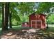 Charming red barn featuring a large sliding door and a smaller adjacent structure, adding rustic charm at 5308 Stableview Ct, Holly Springs, NC 27540