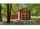 View of a country barn with a red exterior, white trim, and large sliding door at 5308 Stableview Ct, Holly Springs, NC 27540