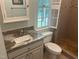 Bathroom featuring a granite countertop vanity, tile shower, and window with shuttered blinds at 5308 Stableview Ct, Holly Springs, NC 27540