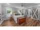 Charming bedroom featuring barn door closet, hardwood floors, and bright natural light from the windows at 5308 Stableview Ct, Holly Springs, NC 27540