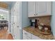 Cozy coffee bar and butler's pantry featuring granite countertops and storage cabinets, enhancing functionality and charm at 5308 Stableview Ct, Holly Springs, NC 27540