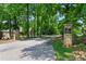 View of the entrance to The Stables private community, featuring a stone sign and tree-lined street at 5308 Stableview Ct, Holly Springs, NC 27540
