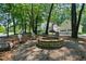 Inviting outdoor fire pit with Adirondack chairs, perfect for gathering and enjoying the wooded surroundings at 5308 Stableview Ct, Holly Springs, NC 27540