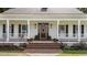 Elegant entryway with a stained wood door, decorative sidelights, and classic white columns at 5308 Stableview Ct, Holly Springs, NC 27540
