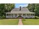 Inviting front porch featuring a brick walkway, manicured lawn, and a charming facade that welcomes you home at 5308 Stableview Ct, Holly Springs, NC 27540