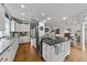 Open-concept kitchen featuring a large island, modern appliances, and seamless flow to the living spaces at 5308 Stableview Ct, Holly Springs, NC 27540