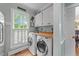 Functional laundry room with modern washer and dryer, ample counter space, and natural light from the window at 5308 Stableview Ct, Holly Springs, NC 27540