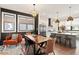 Dining room and kitchen with a large wood table, modern lighting, and stainless-steel appliances at 610 Velma Hopkins Ln, Raleigh, NC 27603