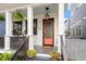 Inviting front porch featuring a coral colored door, hanging lanterns and seating for relaxing at 610 Velma Hopkins Ln, Raleigh, NC 27603