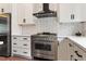 Gourmet kitchen with stainless steel appliances, white cabinets, and modern vent hood at 610 Velma Hopkins Ln, Raleigh, NC 27603