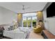 Bedroom featuring balcony access, gray accent wall, ceiling fan, and hardwood floors at 618 N Boylan Ave # 810, Raleigh, NC 27603