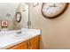 Cozy bathroom features a stylish sink and countertop, complemented by a charming wall clock and decorative mirror at 628 Kankakee Ct, Knightdale, NC 27545