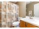 Charming bathroom featuring a patterned shower curtain, white toilet and sink with wood cabinet at 628 Kankakee Ct, Knightdale, NC 27545