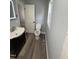 This bathroom features bead board paneling, gray luxury vinyl plank flooring, a sink and toilet at 65 Prospect Church Rd, Erwin, NC 28339