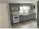 Well-lit kitchen features gray cabinetry, a white farmhouse sink, and stainless steel appliances at 65 Prospect Church Rd, Erwin, NC 28339