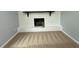 Spacious living room featuring a white-painted brick fireplace, neutral carpeting, and light-grey walls at 65 Prospect Church Rd, Erwin, NC 28339