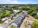 Aerial view of townhomes nestled among trees, showing streetscapes and a nearby construction area under a blue sky at 710 W North St # 103, Raleigh, NC 27603