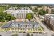 High-angle view of modern townhomes with neat landscaping and a backdrop of urban buildings, foliage, and a blue sky at 710 W North St # 103, Raleigh, NC 27603