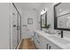 Modern bathroom with dual sinks, black fixtures, and glass-enclosed shower at 710 W North St # 103, Raleigh, NC 27603