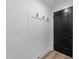 Minimalist entryway features built-in storage, black door, light wood flooring, and clean white walls at 710 W North St # 103, Raleigh, NC 27603