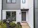 Up-close view of a modern townhome's entrance with clean lines, mixed siding, and manicured landscaping at 710 W North St # 103, Raleigh, NC 27603