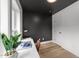 Sleek home office design with contrasting dark gray accent wall, white desk, and light wood floors at 710 W North St # 103, Raleigh, NC 27603