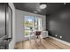 Modern home office features gray accent wall, contemporary desk, and natural light from a window with a view at 710 W North St # 103, Raleigh, NC 27603